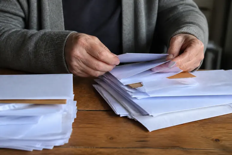 Tri de courriers administratifs avec des enveloppes postales sur un bureau en bois