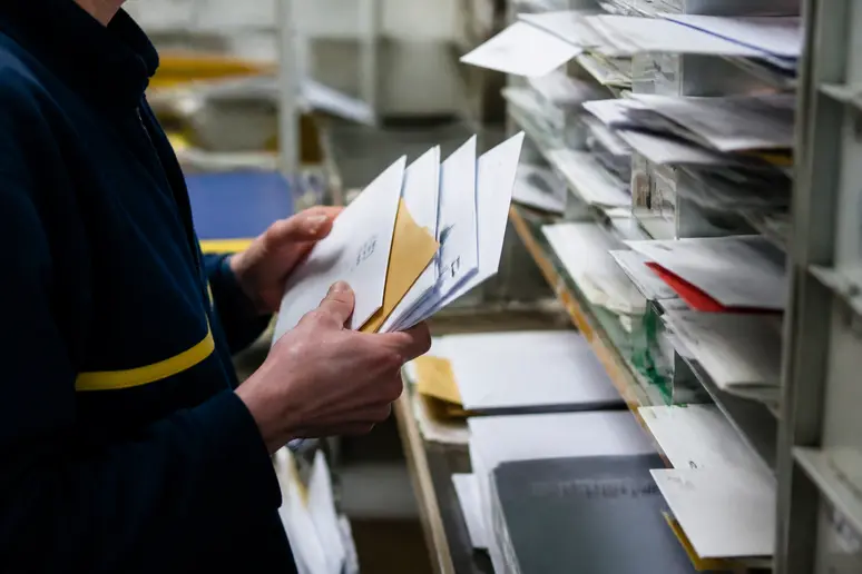 Employé de la poste triant du courrier postal pour les différentes adresses de Caen
