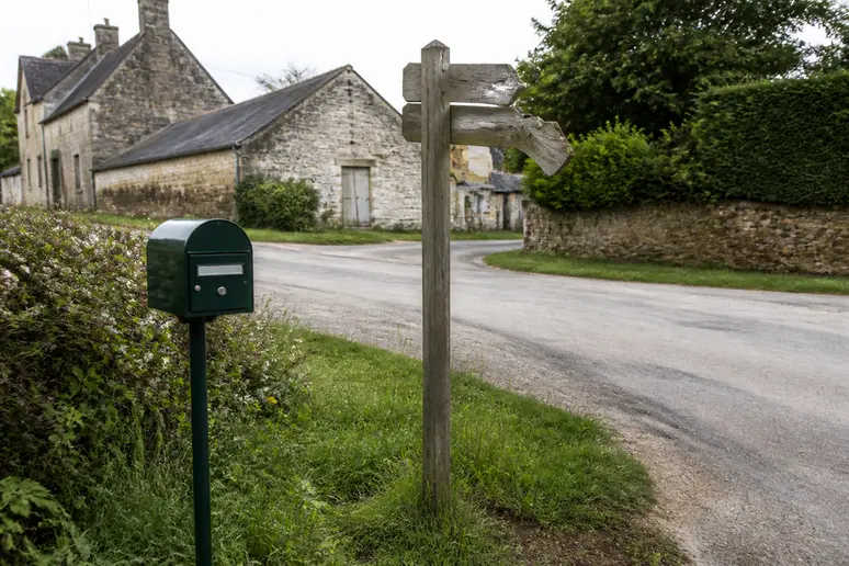 Panneau de signalisation et boîte aux lettres près d'un village partageant le code postal 14600