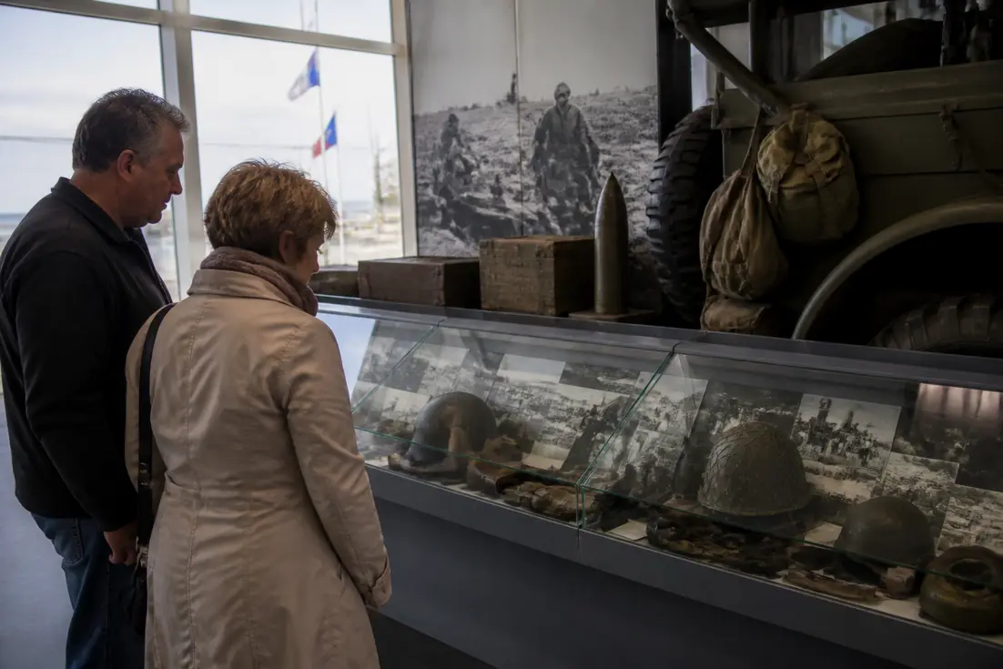 Deux visiteurs découvrent les expositions historiques lors de leur démarche pour visiter musées America Gold Beach.