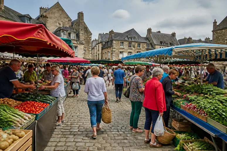 Étals animés d'un marché traditionnel en plein air sur une place de Caen.