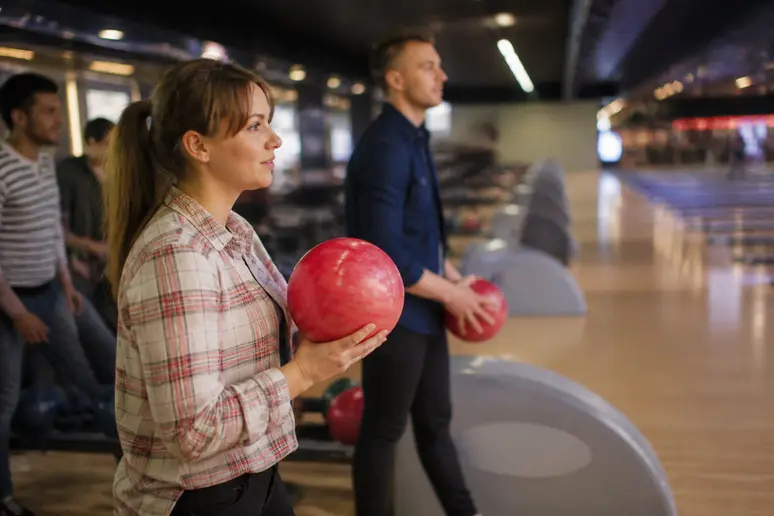 Joueurs attendant près des pistes de bowling au sein d'un complexe de loisirs animé.