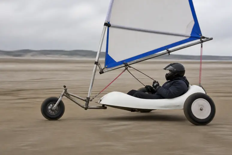 Pilote équipé d'un casque à bord d'un char à voile sur une plage de Normandie