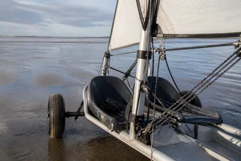 Char à voile biplace stationné sur l'estran sablonneux prêt pour une session en duo