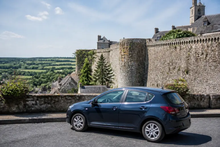 Voiture stationnée sur un parking gratuit en périphérie d'un site historique normand