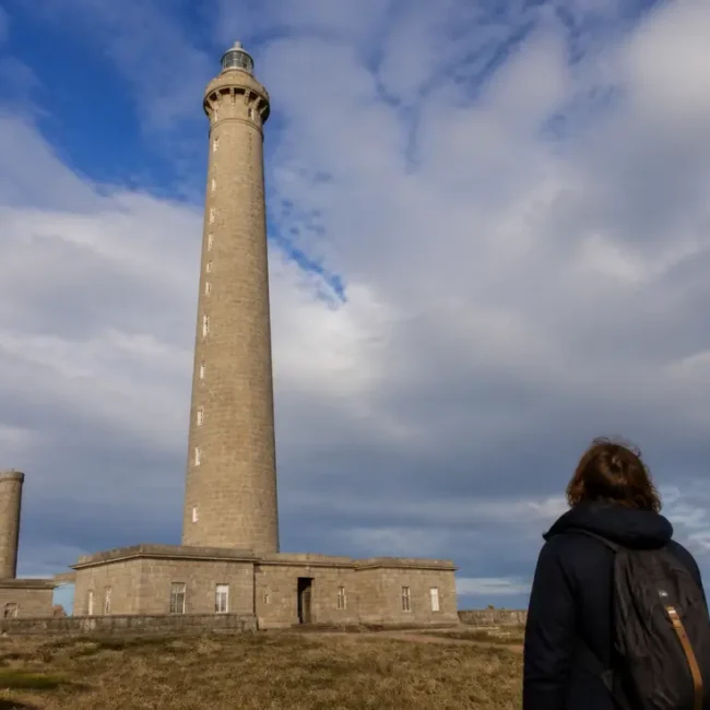 Visiteur observant la façade en pierre lors de ses Gatteville le Phare conseils visite en Normandie
