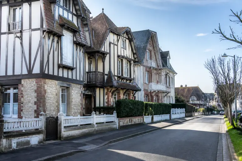 Rue résidentielle calme bordée d'architecture normande traditionnelle à Blonville-sur-Mer.