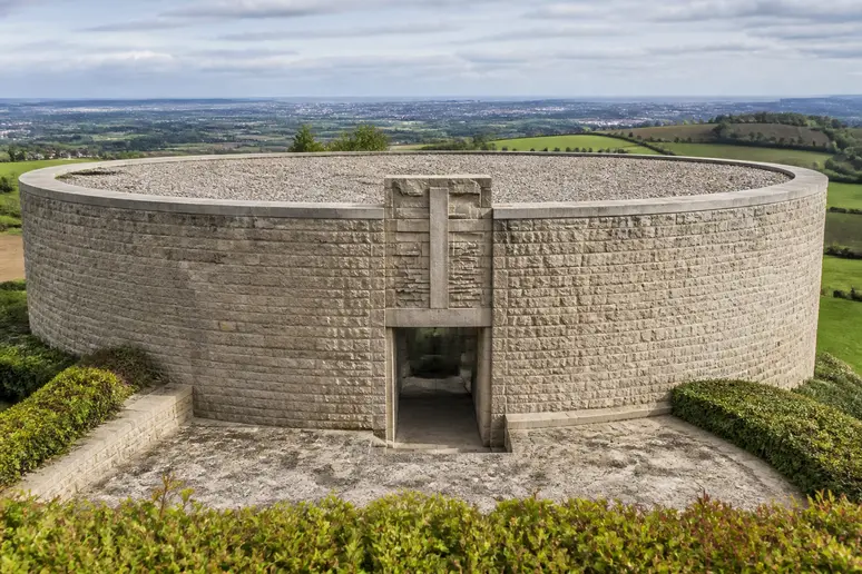 Vue extérieure de l'ossuaire circulaire d'une nécropole militaire allemande en bordure de paysage normand.