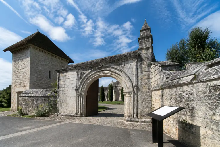 Entrée principale en pierre avec signalétique pour préparer visite Abbaye de La Lucerne