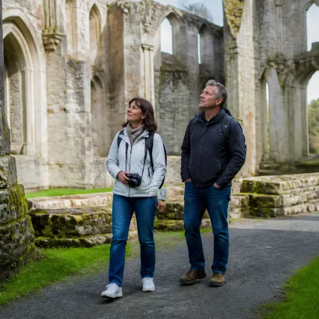 Couple de touristes découvrant les vestiges en pierre lors de leur préparer visite Abbaye de La Lucerne en Normandie.
