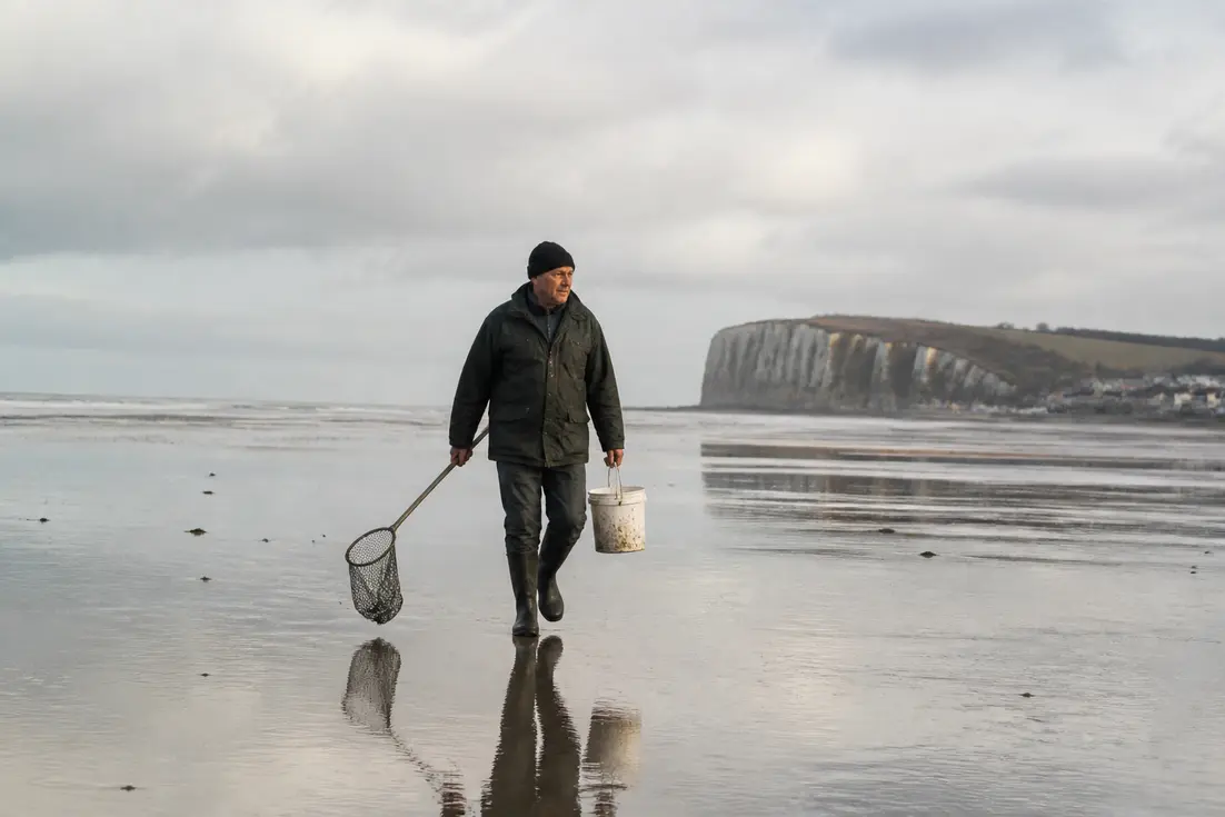 Pêcheur à pied sur la plage lors des marées Pourville quand partir avec son seau