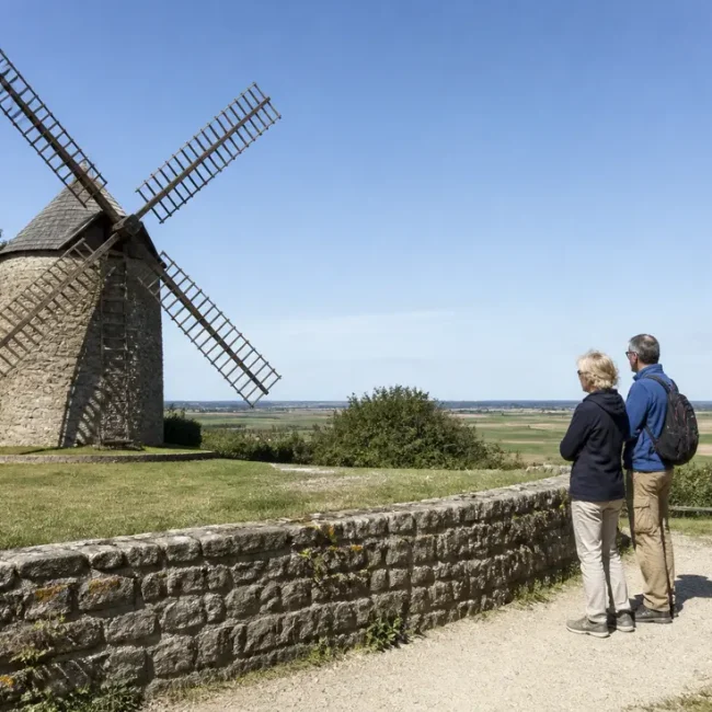 Un couple découvre l'extérieur du site pour visiter Moulin de Moidrey en Normandie