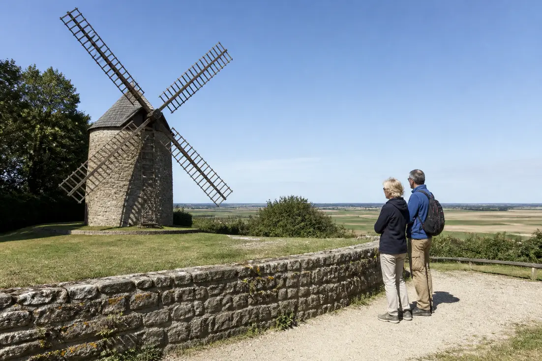 Un couple découvre l'extérieur du site pour visiter Moulin de Moidrey en Normandie